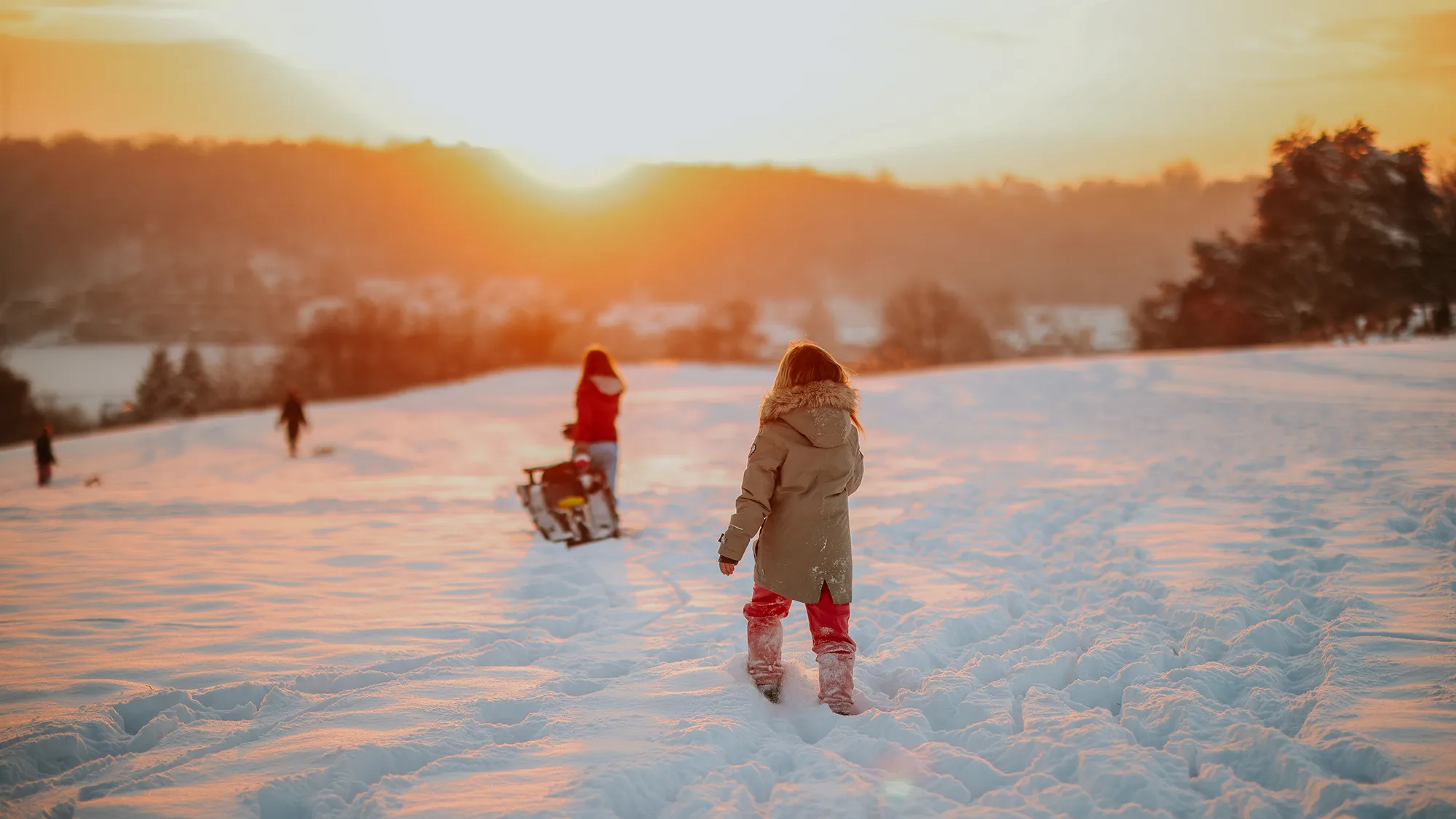Kinder laufen durch den Wintertraum bei Sonnenuntergang in Merkstein