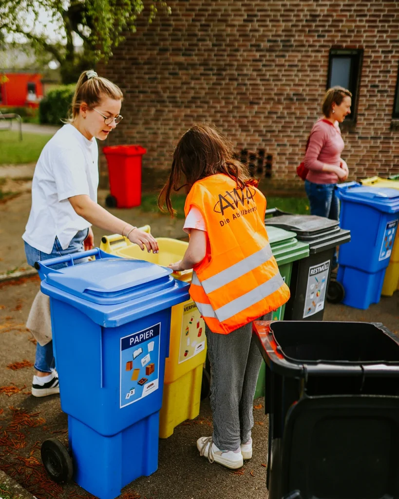 Kind trennt Verpackungsmüll richtig beim Mülltrennung Projekt im Kinderheim