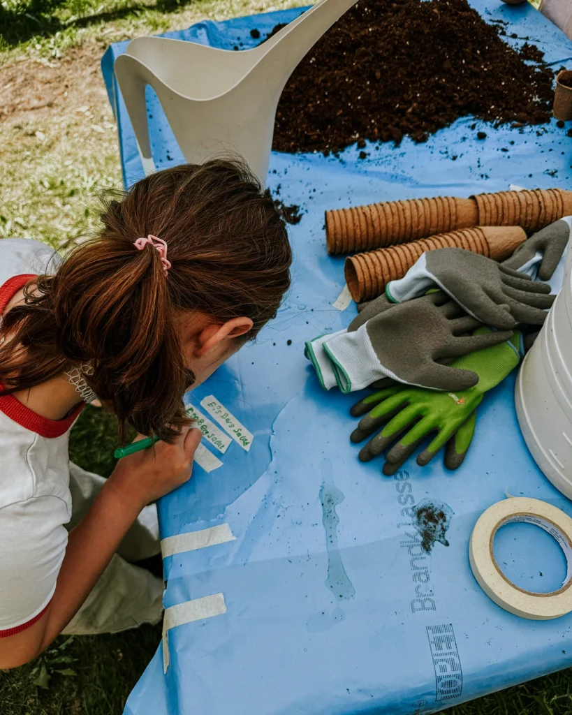 Kinder pflanzen Gemüse in ein Hochbeet im Kinderheim