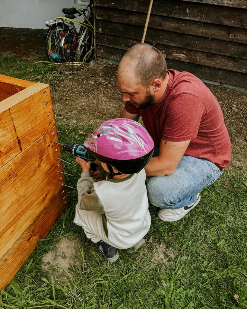 Kinder bauen gemeinsam an einem Hochbeet im Kinderheim Merkstein