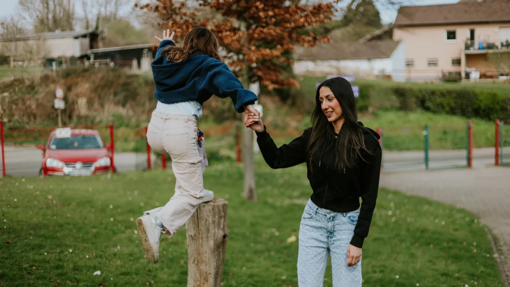 Eine junge Frau unterstützt ein Kind beim Spielen im Kinderheim Merkstein