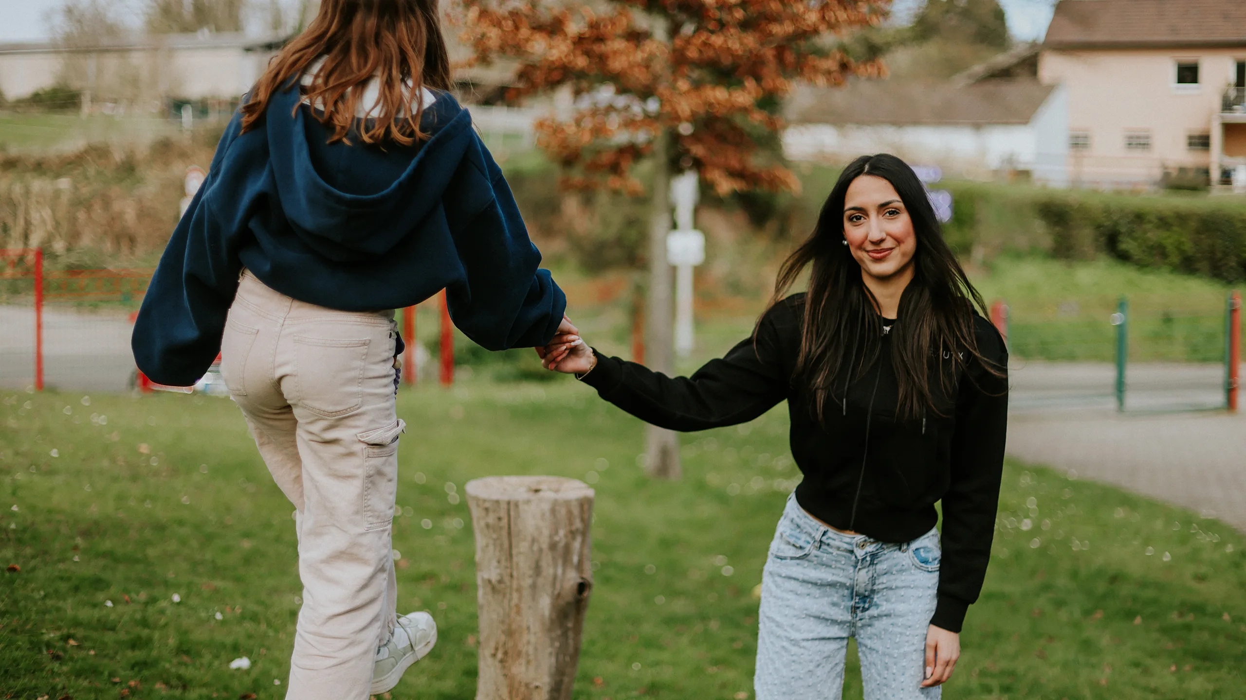 Eine Frau, die ihr freiwilliges soziales Jahr macht, spielt mit einem Mädchen, das balanciert.