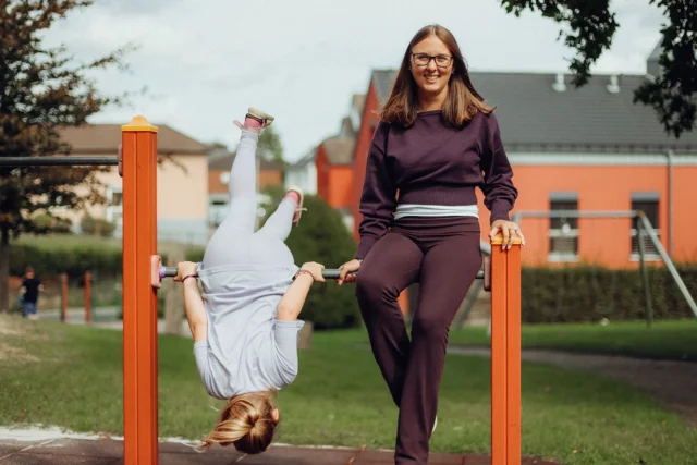 Eine Werkstudentin begleitet ein Kind beim Spielen im Kinderheim